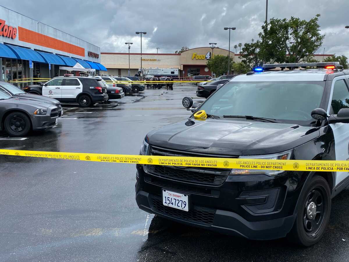 Police cars and yellow tape in a parking lot