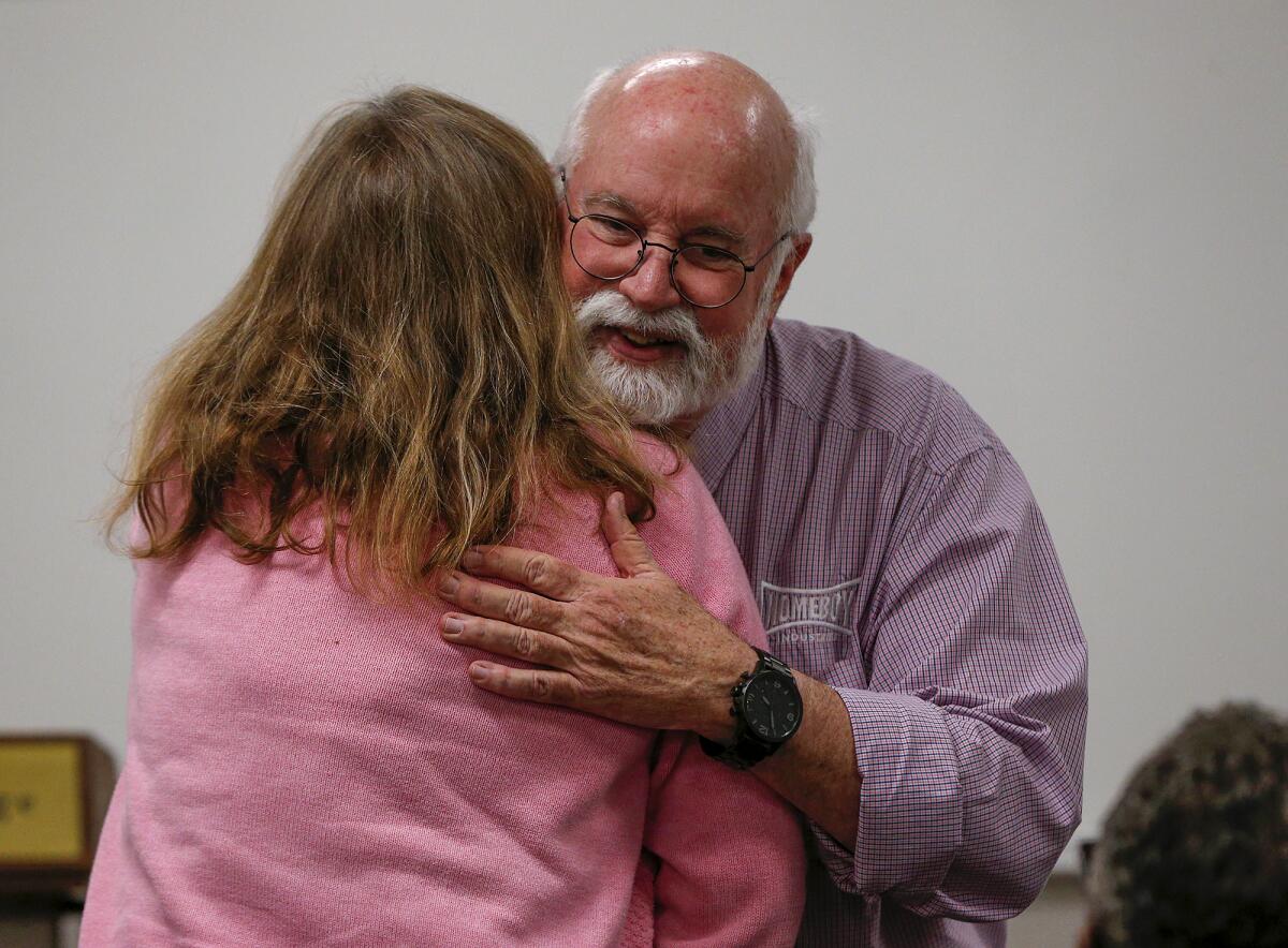 Father Greg Boyle hugs a thankful guest and staff member who attended a talk Tuesday at Orange Coast College.
