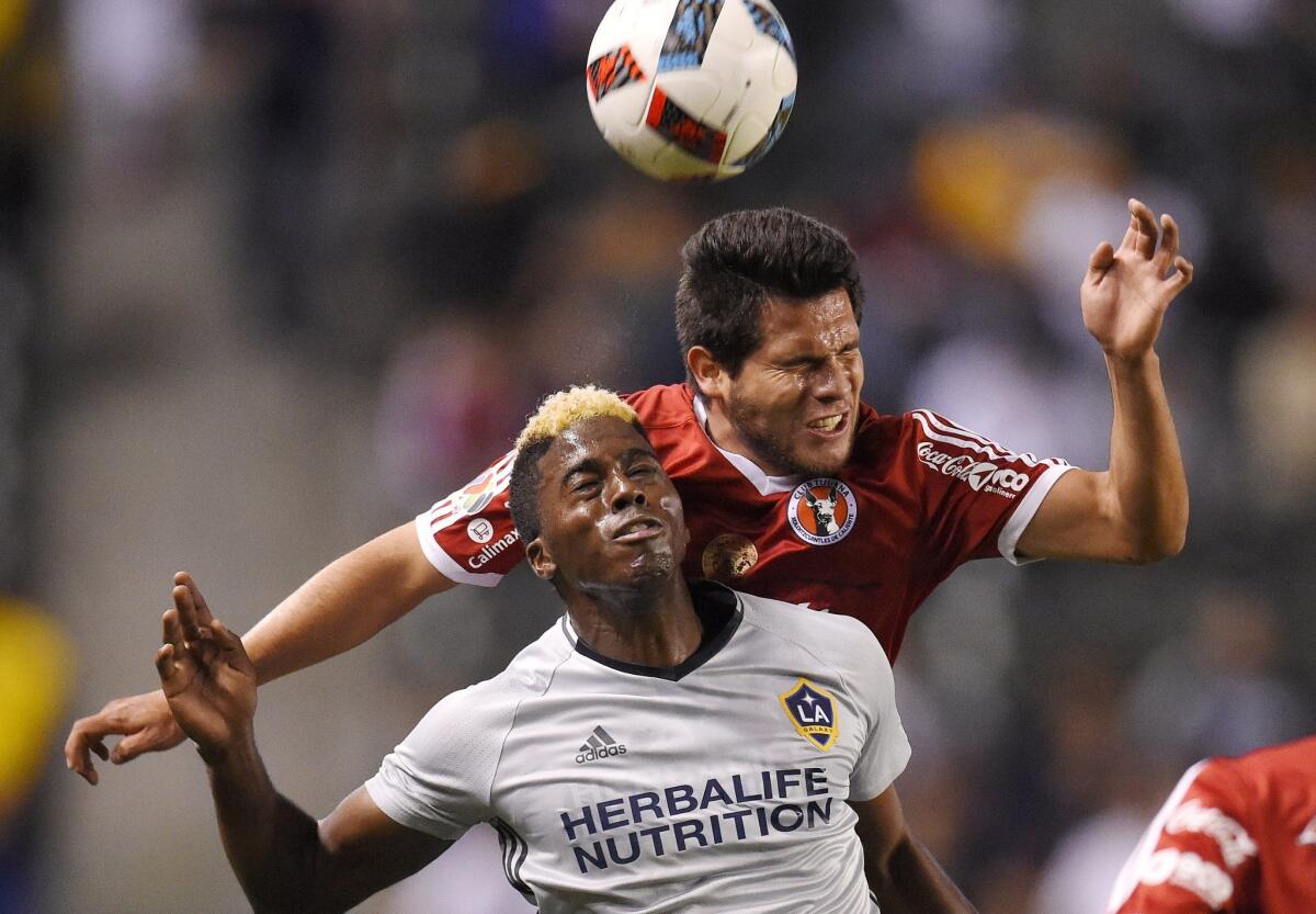 Los Angeles Galaxy forward Gyasi Zardes, left, tries to head the ball along with Club Tijuana defender Hiram Munoz during the first half of a soccer match, Tuesday, Feb. 9, 2016, in Carson, Calif. (AP Photo/Mark J. Terrill)