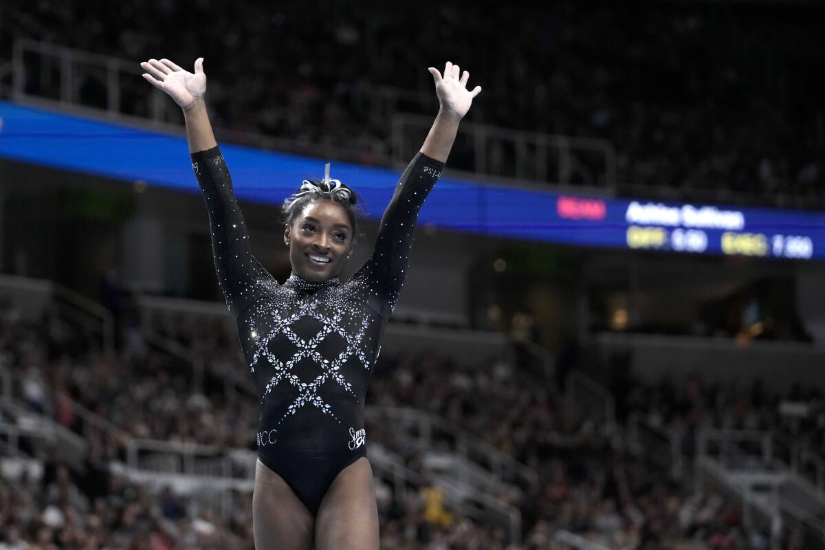 Simone Biles reacts after competing on the floor exercise.