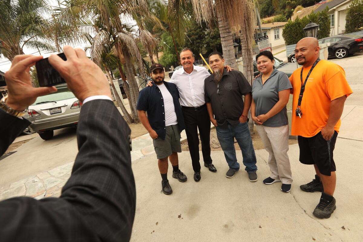 Los Angeles Mayoral Candidate Rick Caruso, in white shirt, has a photo taken with Highland Park residents