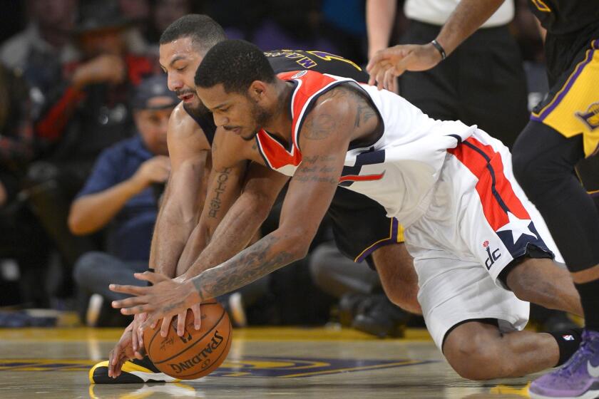 Trevor Ariza and Kendall Marshall chase a loose ball during the first half of a game on March 21. Ariza was traded to the Houston Rockets by the Washington Wizards as part of a three-team deal also involving the New Orleans Pelicans.