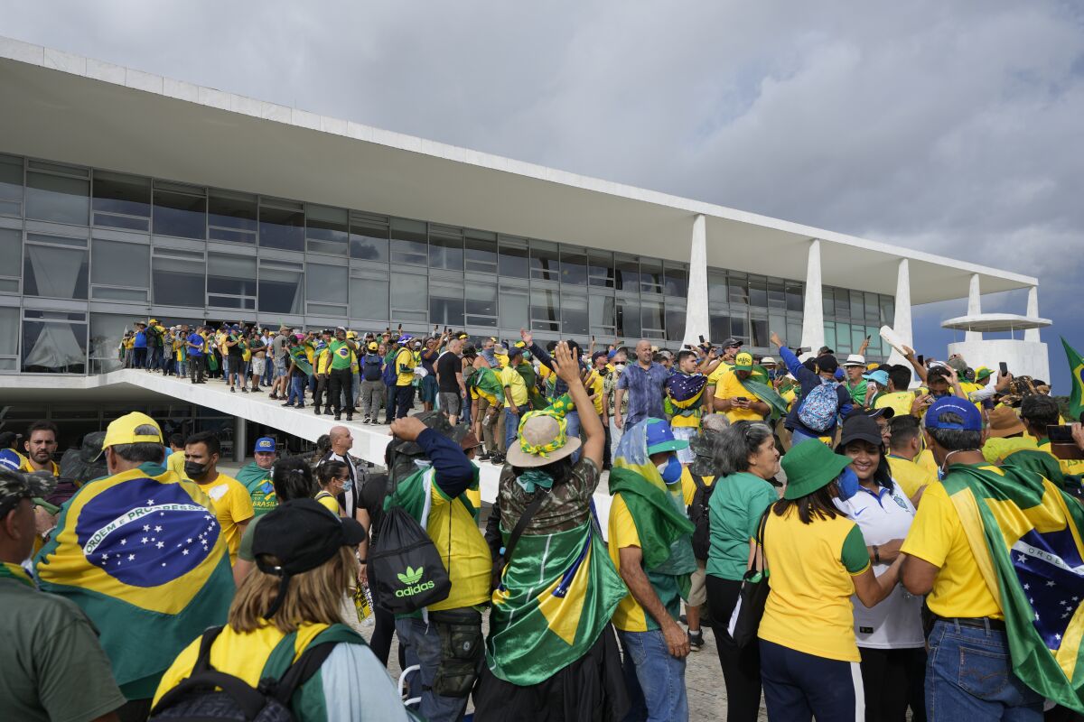 身穿黃色和綠色衣服的博爾索納羅支持者衝進總統府。