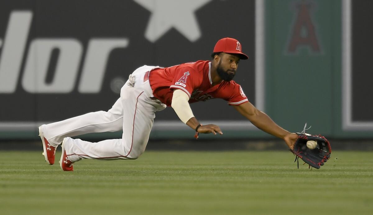 Angels outfielder Brian Goodwin dives for a ball hit by Milwaukee's Lorenzo Cain on April 10 in Anaheim.