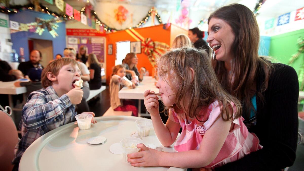 Nathan Palat, 5, enjoys vanilla ice cream with his sister, Ava, 4, held by mother Colleen, after a performance at the Bob Baker Marionette Theater in Downtown Los Angeles in 2012.