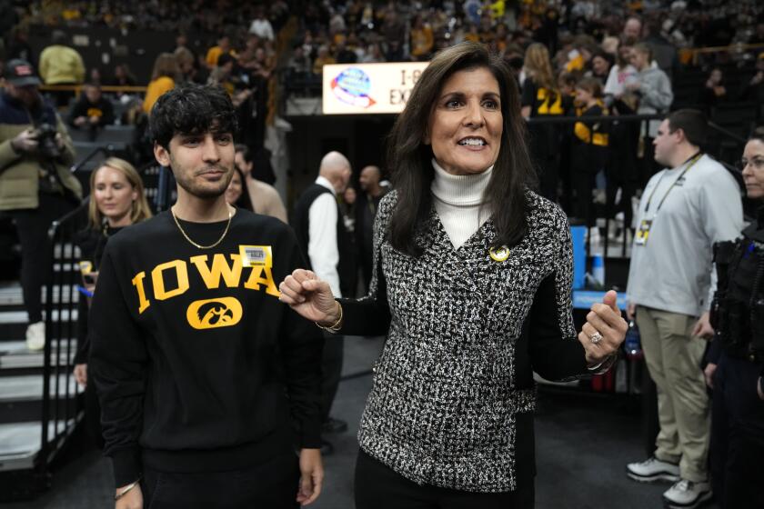 Republican presidential candidate Nikki Haley arrives with her son Nalin, left, at an NCAA college basketball game between Iowa and Minnesota, Saturday, Dec. 30, 2023, in Iowa City, Iowa. (AP Photo/Charlie Neibergall)