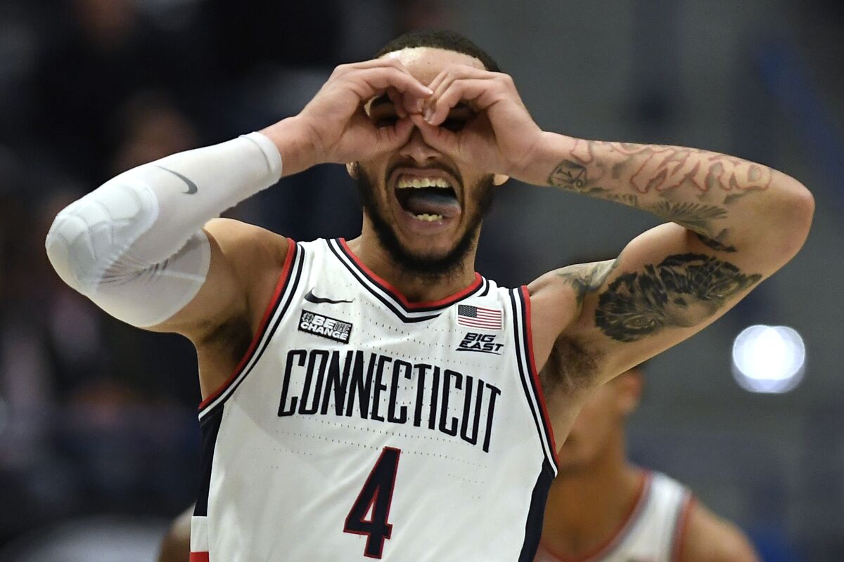 Connecticut's Tyrese Martin gestures after making a basket in the first half of an NCAA college basketball game against Marquette, Tuesday, Feb. 8, 2022, in Hartford, Conn. (AP Photo/Jessica Hill)