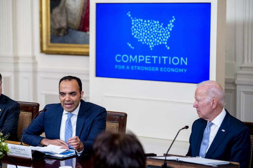 Consumer Financial Protection Bureau director Rohit Chopra, left, accompanied by President Joe Biden, right, speaks at a meeting with his Competition Council on the economy and prices in the East Room of the White House in Washington, Wednesday, Feb. 1, 2023. (AP Photo/Andrew Harnik)