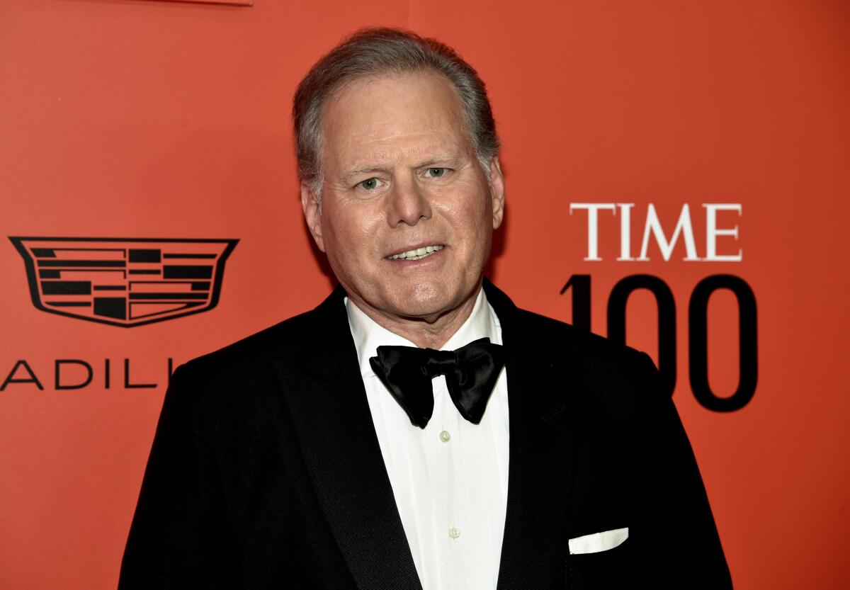 David Zaslav is posing and smiling in a black tuxedo with a white shirt and pocket square, and a black bowtie. 