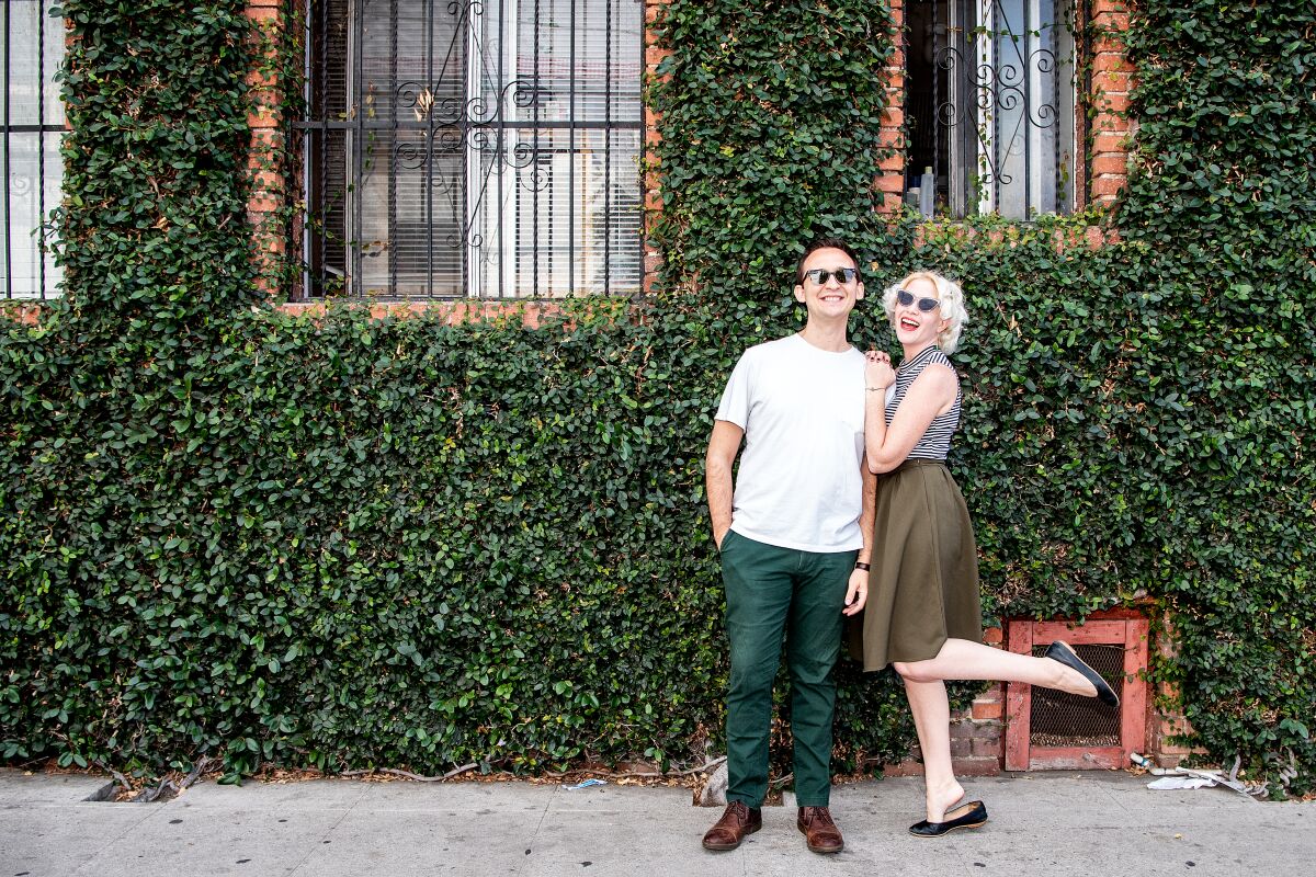 Two people standing in front of an ivy-covered building.