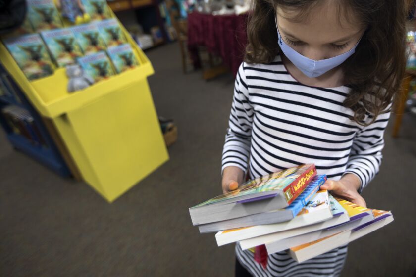 MONTROSE, CA - OCTOBER 24: Elli Tatiyants, 7, of Glendale, picks out some books at Once Upon a Time Bookstore speaks with customers on Saturday, Oct. 24, 2020 in Montrose, CA. Once Upon a Time Bookstore in Montrose, the country's oldest children's bookstore. Now, Once Upon a Time is struggling during the coronavirus pandemic. (Francine Orr / Los Angeles Times)