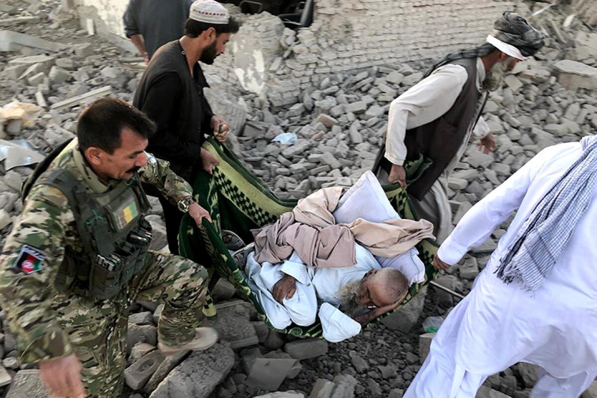 An injured man is carried from the scene of a suicide bombing Sept. 19 in Zabul province, Afghanistan.