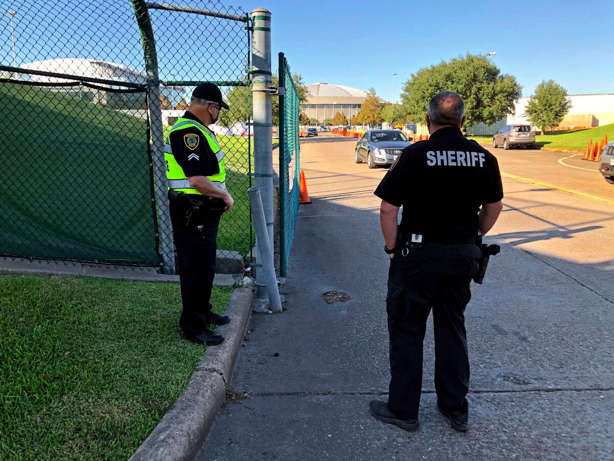 Harris County Sheriff's Deputy R. Hilz and Houston Police Officer T. Jones at a Houston stadium parking lot polling place.