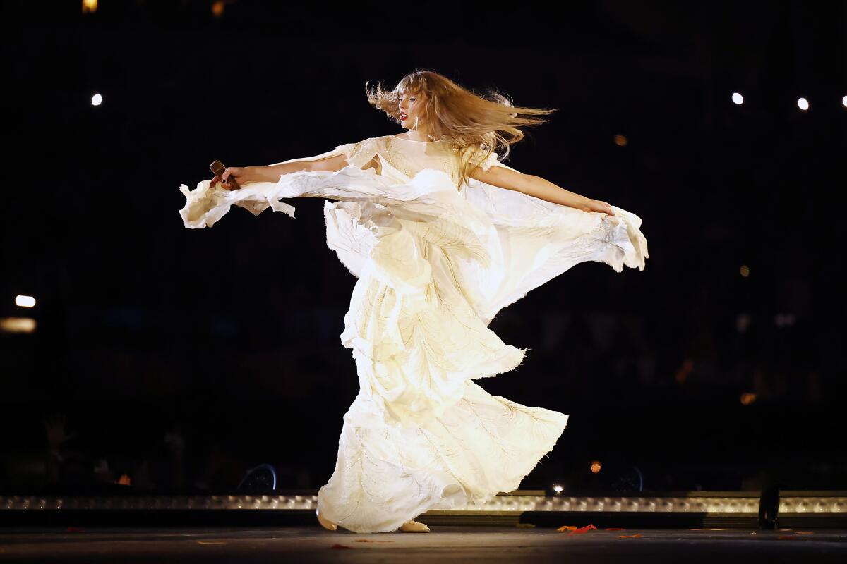 A woman in a long white dress spins onstage.