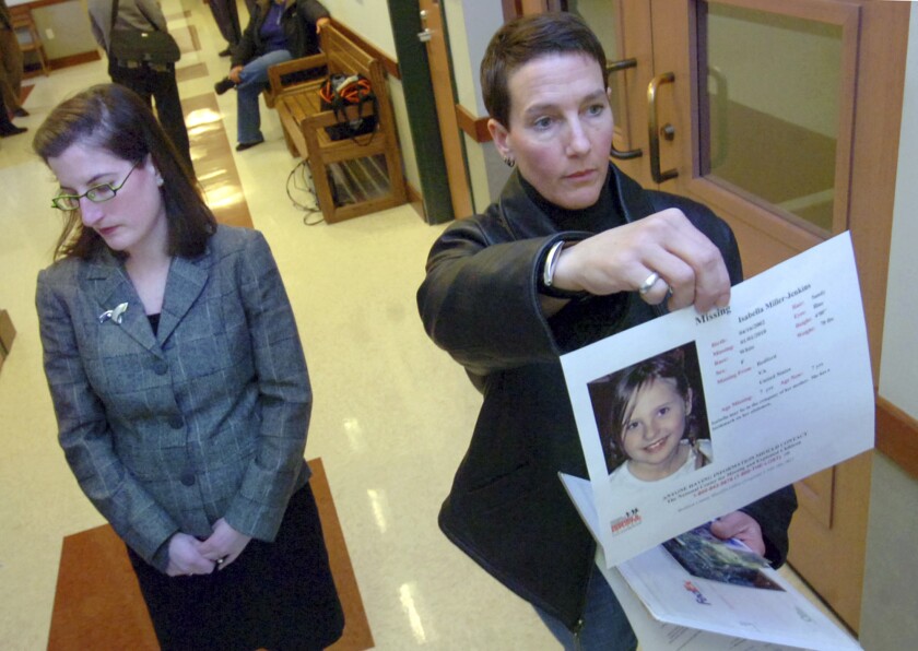 Janet Jenkins, right, of Fair Haven, Vt. who is involved in a same-sex custody battle with Virginia mother Lisa Miller, holds up a photo of her daughter, Isabella, for television cameras after a family court judge in Rutland, Vt., issued an arrest warrant for Lisa Miller on Tuesday, Feb. 23, 2010. A woman who allegedly fled the United States for Nicaragua in 2009 rather than share custody of her child with her former same-sex partner has been arrested in Miami. Federal court records say that Lisa Miller was taken into federal custody Jan. 27. She is awaiting transfer to Buffalo, New York, where she was indicted in 2014 on international parental kidnapping charges. (Vyto Starinskas/Rutland Herald via AP, file)