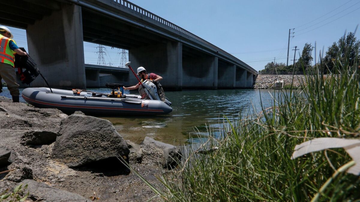 Caltrans student assistant Rami Gharaibeh prepares a small inflatable boat with bridge engineer Kevin Flora.