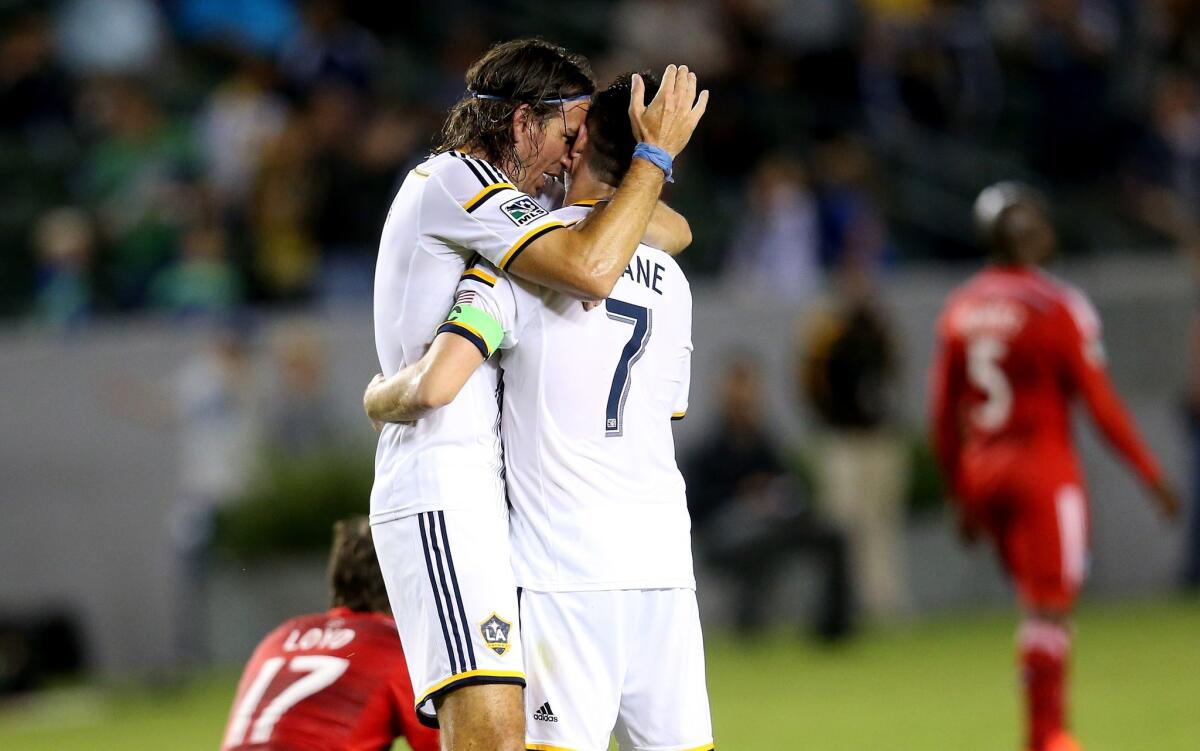 Alan Gordon embraces Galaxy teammate Robbie Keane (7) after scoring a goal against FC Dallas on Sept. 20.