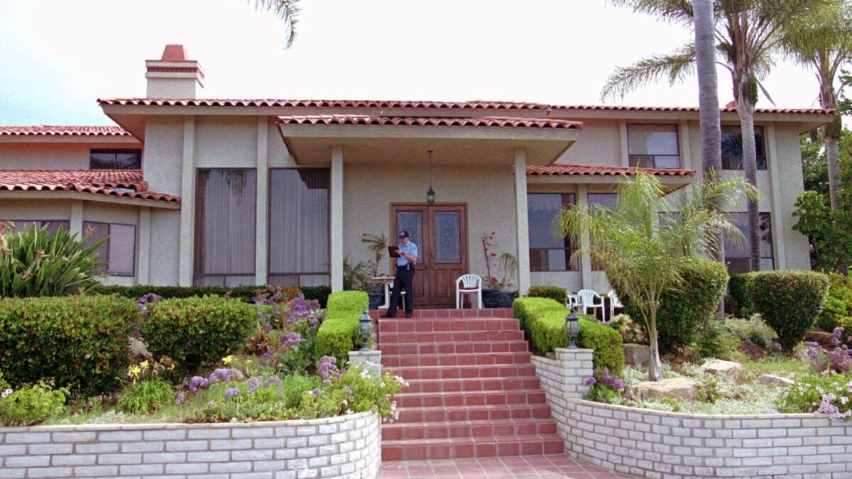 An unidentified security guard stands guard in front of the Rancho Santa Fe, Calif. mansion May 5, 1997, where 39 Heaven's Gate cult members killed themselves in March 1997.