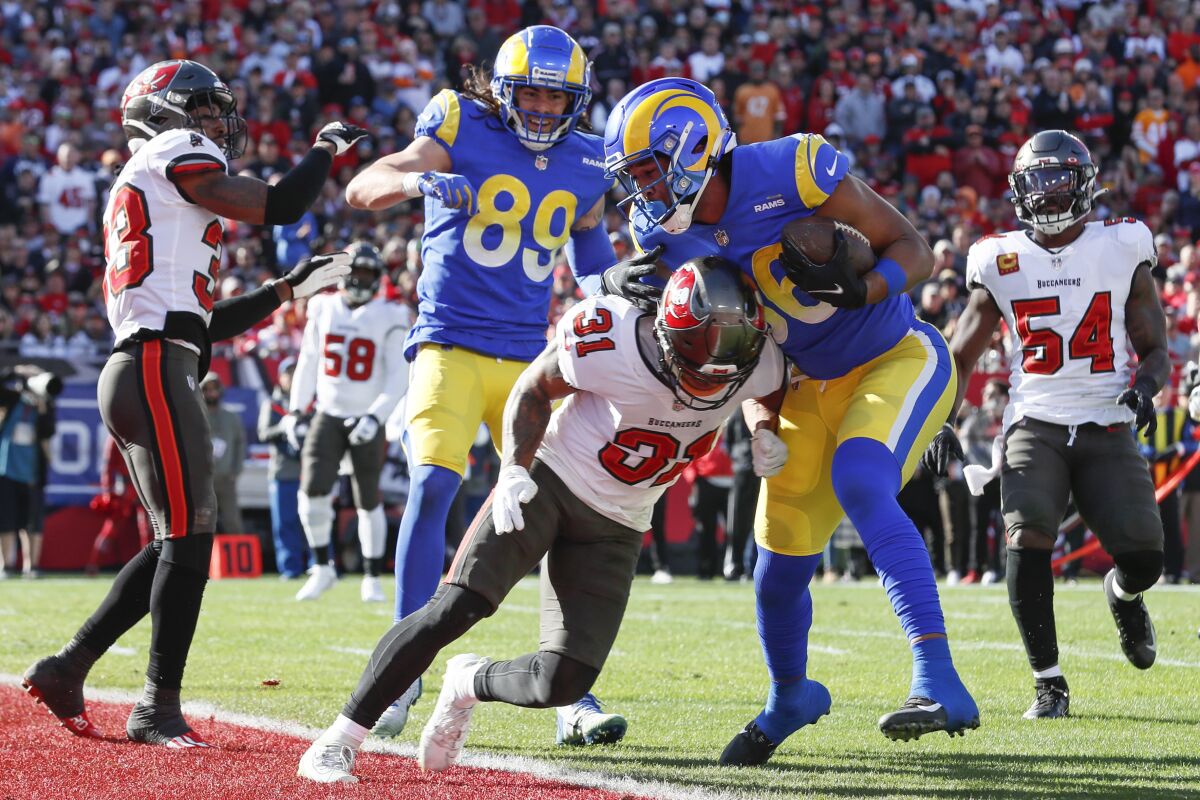 Rams tight end Kendall Blanton scores a touchdown as he is hit by Tampa Bay Buccaneers defensive back Antoine Winfield II.