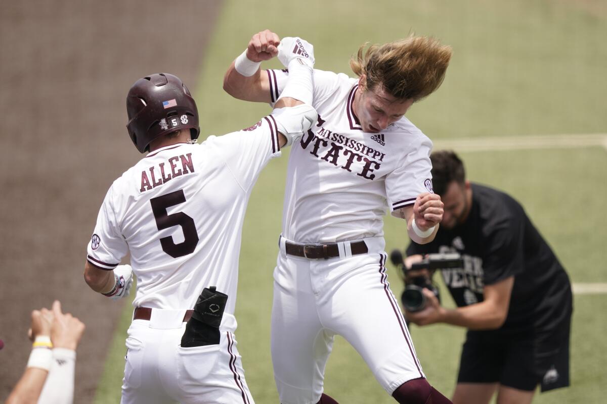 Mississippi State's Tanner Allen (5) congratulated by teammate Rowdey Jordan after hitting a home run against Notre Dame during the first inning of an NCAA college baseball super regional game, Saturday, June 12, 2021, in Starkville, Miss. (AP Photo/Rogelio V. Solis)