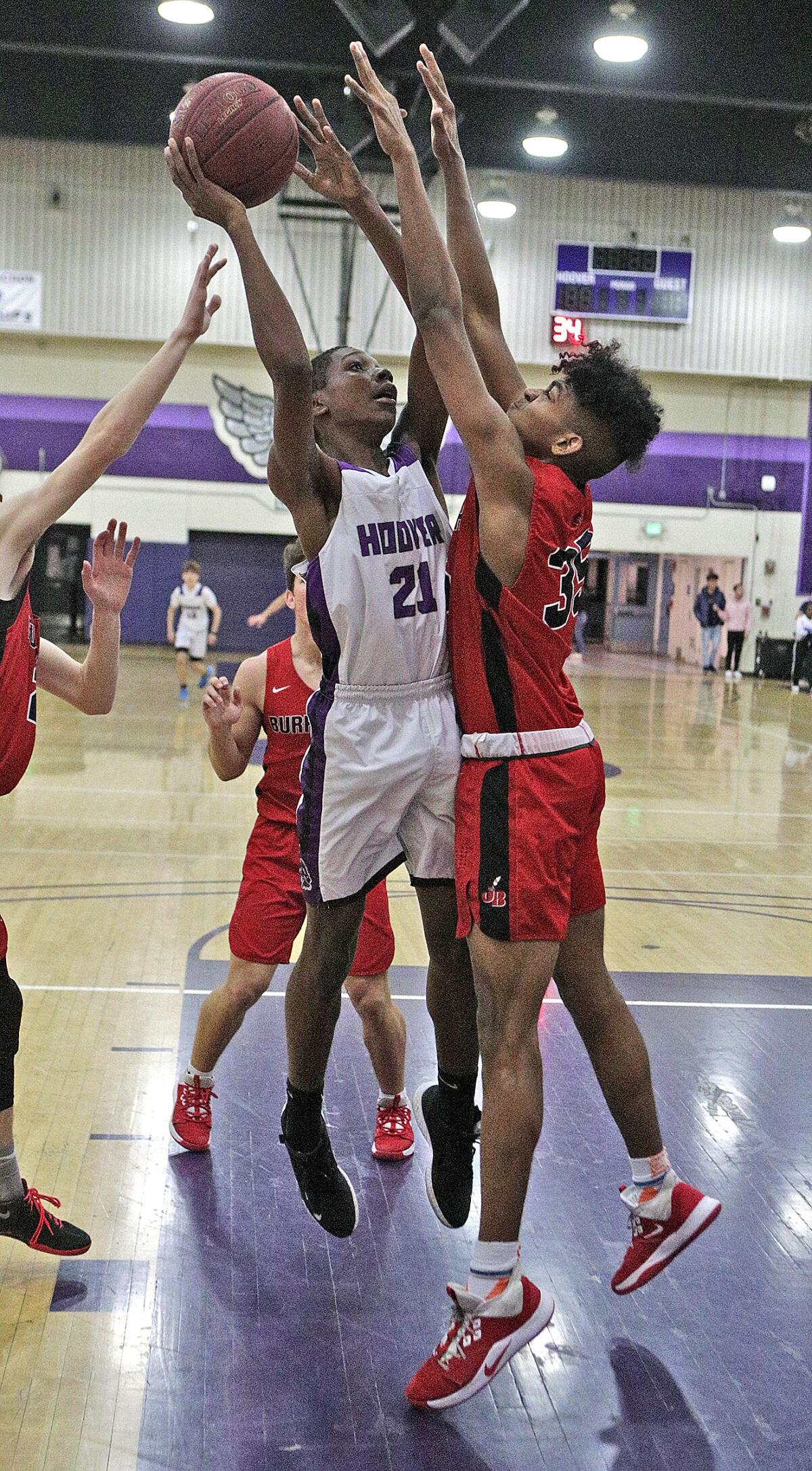 Hoover's Jeremiah Townsend puts the ball back up after a rebound to shoot against Burroughs' Corwin Smith in a Pacific League boys' basketball game at Hoover High School on Friday, January 24, 2020.