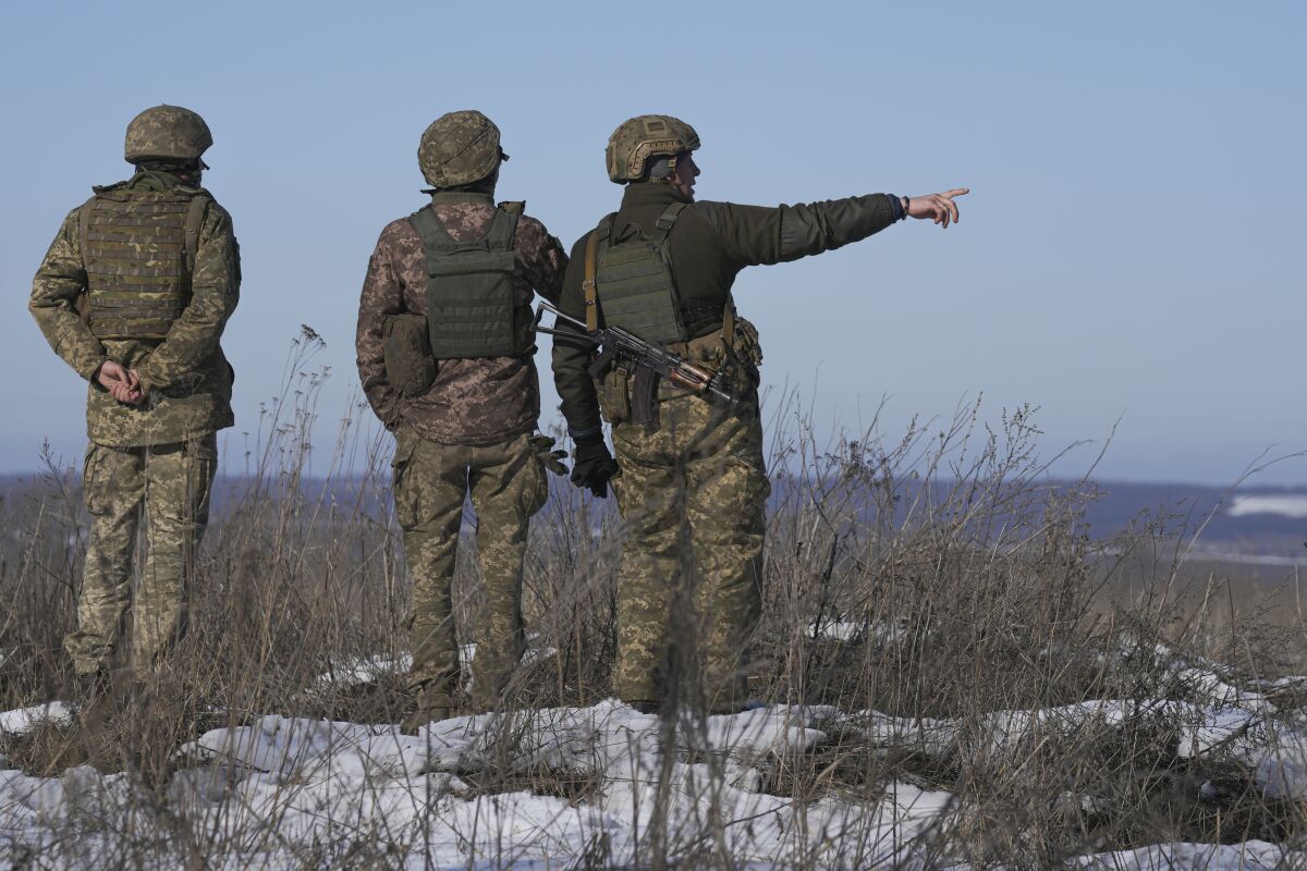 Ukrainian servicemen survey the impact areas from shells that landed close to their positions during the night on a front line outside Popasna, Luhansk region, eastern Ukraine, Monday, Feb. 14, 2022. Russia's Foreign Minister Sergey Lavrov advised President Vladimir Putin on Monday to keep talking with the West on Moscow's security demands, a signal from the Kremlin that it intends to continue diplomatic efforts amid U.S. warnings of an imminent Russian invasion of Ukraine.(AP Photo/Vadim Ghirda)