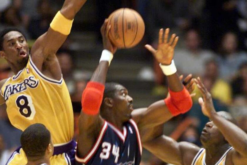The Lakers' Kobe Bryant and Shaquille O'Neal try to block the shot of Rockets center Hakeem Olajuwon during a 1999 playoff game.