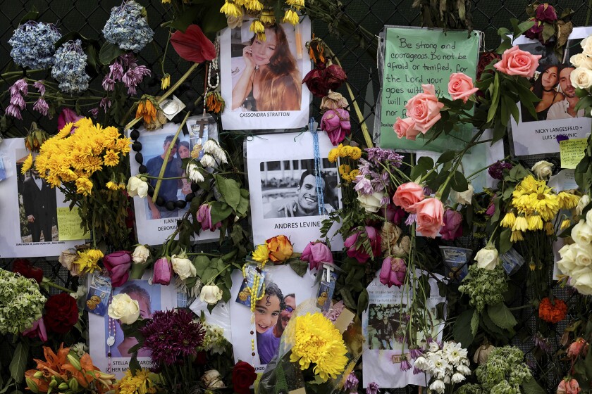 Photographs, flowers and notes on a memorial wall  