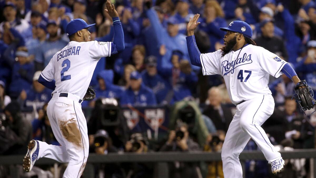 Royals pitcher Johnny Cueto (47) celebrates with Alcides Escobar after the shortstop fielded a grounder by the Mets' Juan Lagares and threw to first base to end the eighth inning.