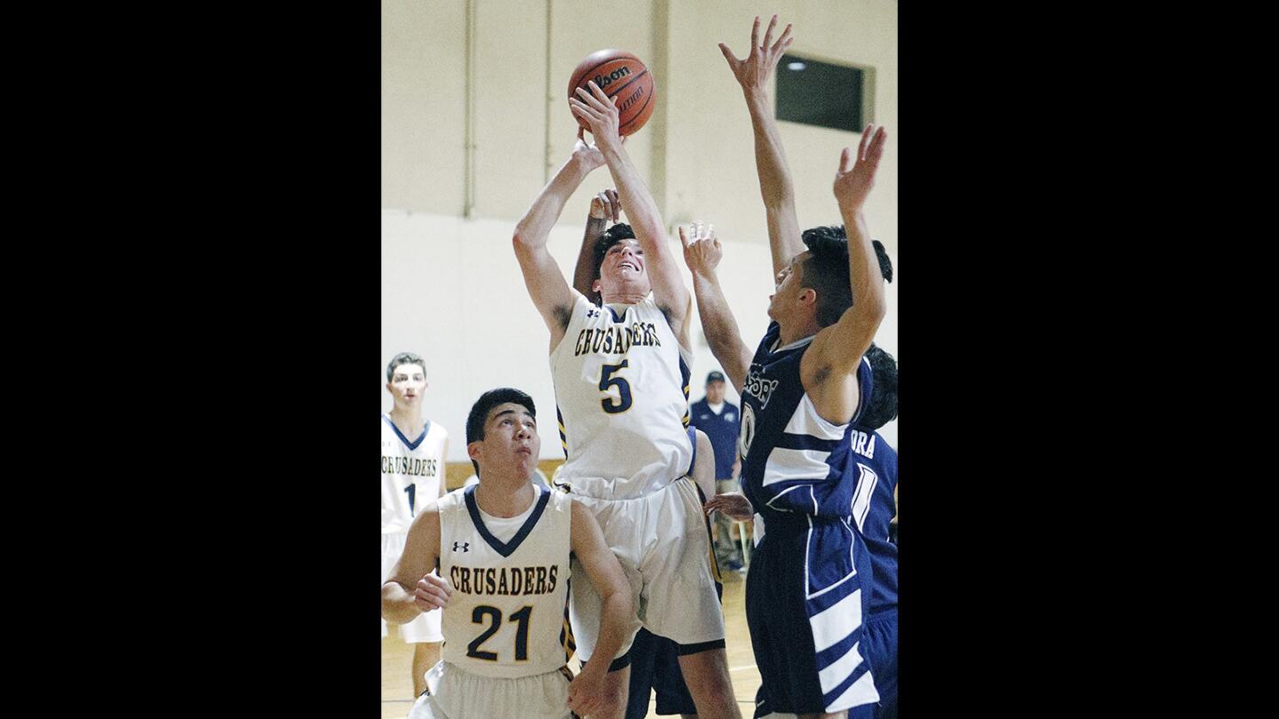 St. Monica Academy's Charlie Boles, in a group, shoots against New Harvest Christian's Joe Morales in a boys' basketball game at New Revelation Baptist Church in Pasadena on Thursday, February 1, 2018.