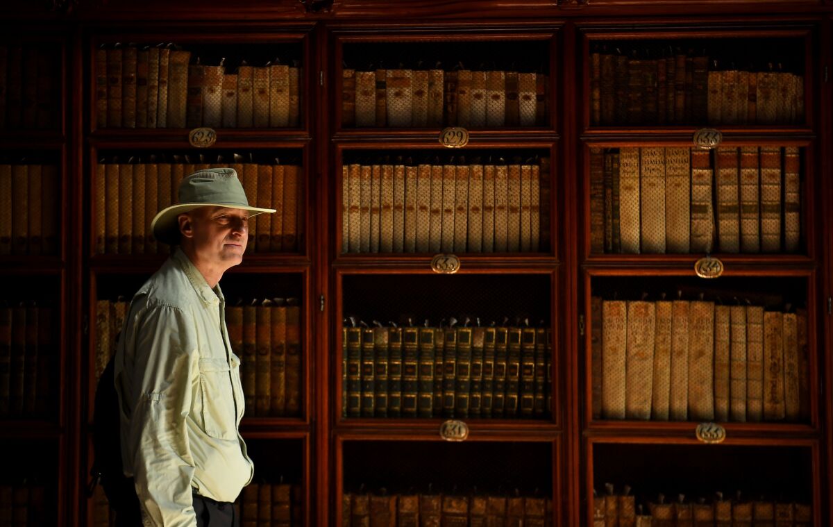 A man walks by old books at the Biblioteca Palafoxiana in Puebla, Mexico.