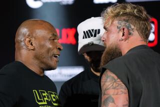 Mike Tyson, left, and Jake Paul, right, face off during a news conference promoting their upcoming boxing bout