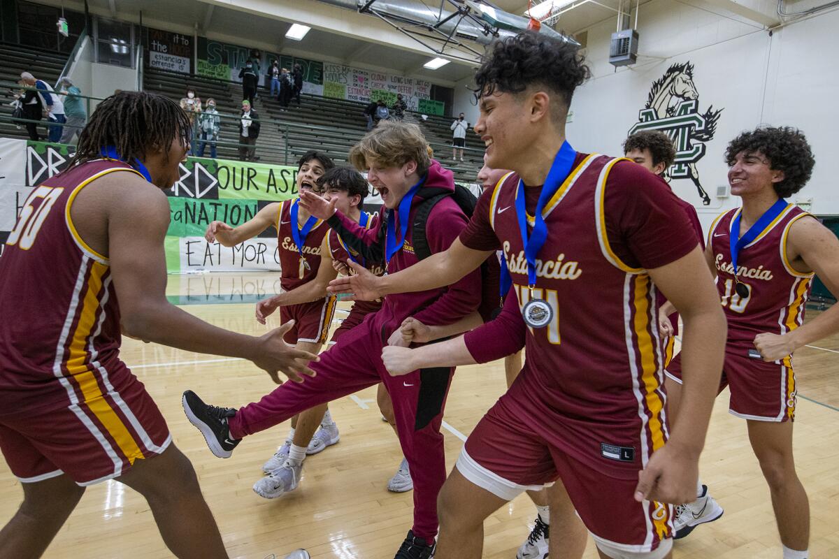 The Estancia boys' basketball team celebrates winning the Battle for the Bell on aggregate score.