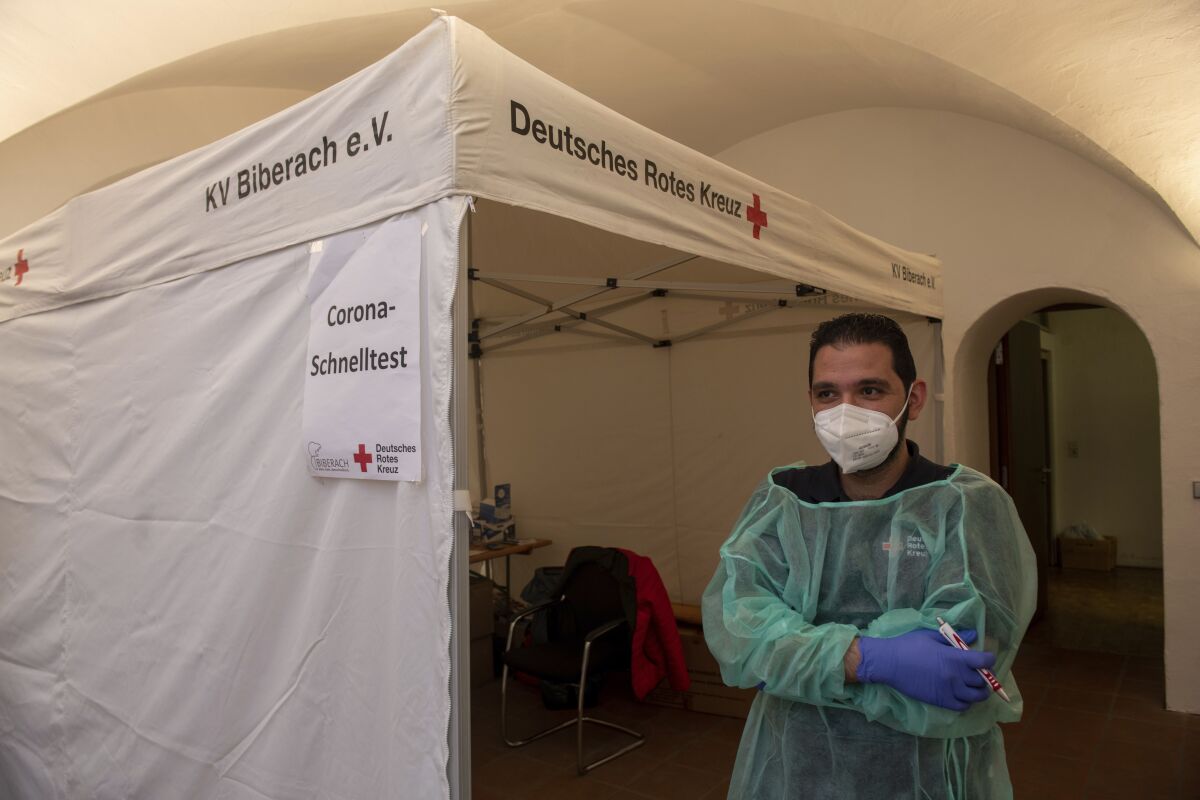 Red Cross worker Motasen Edrees stands in front of a tent at City Hall where he performs Corona rapid tests in Biberach, Germany, Wednesday, Nov. 10, 2021. Biberach County has the highest seven-day incidence in the country, with more than 500. (Stefan Puchner/dpa via AP)