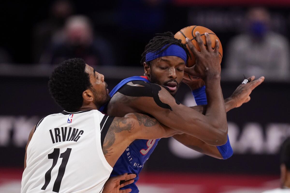 Brooklyn Nets guard Kyrie Irving reaches in on Detroit Pistons forward Jerami Grant.