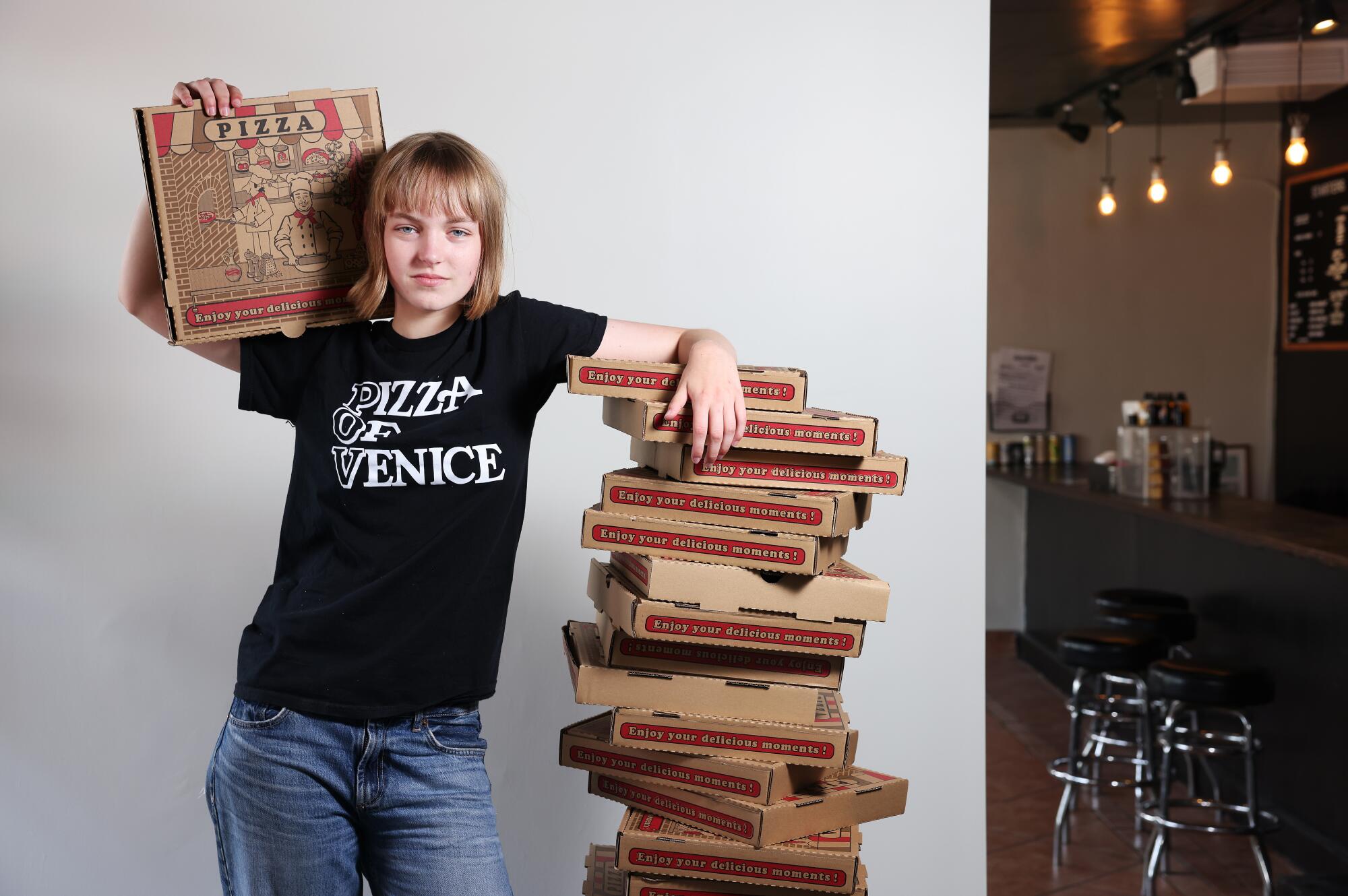 Sookie Orth with a stack of pizza boxes