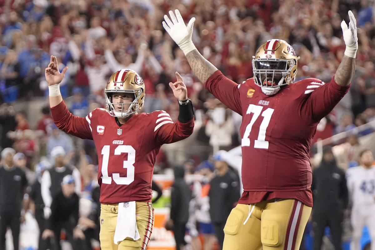 San Francisco 49ers quarterback Brock Purdy and offensive tackle Trent Williams, right, celebrate after a touchdown.