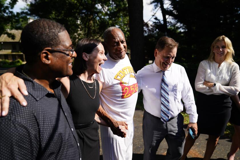 Bill Cosby, center, listens to members of his team speaks with members of the media outside Cosby's home in Elkins Park, Pa., Wednesday, June 30, 2021, after Pennsylvania's highest court overturned his sex assault conviction. (AP Photo/Matt Rourke)