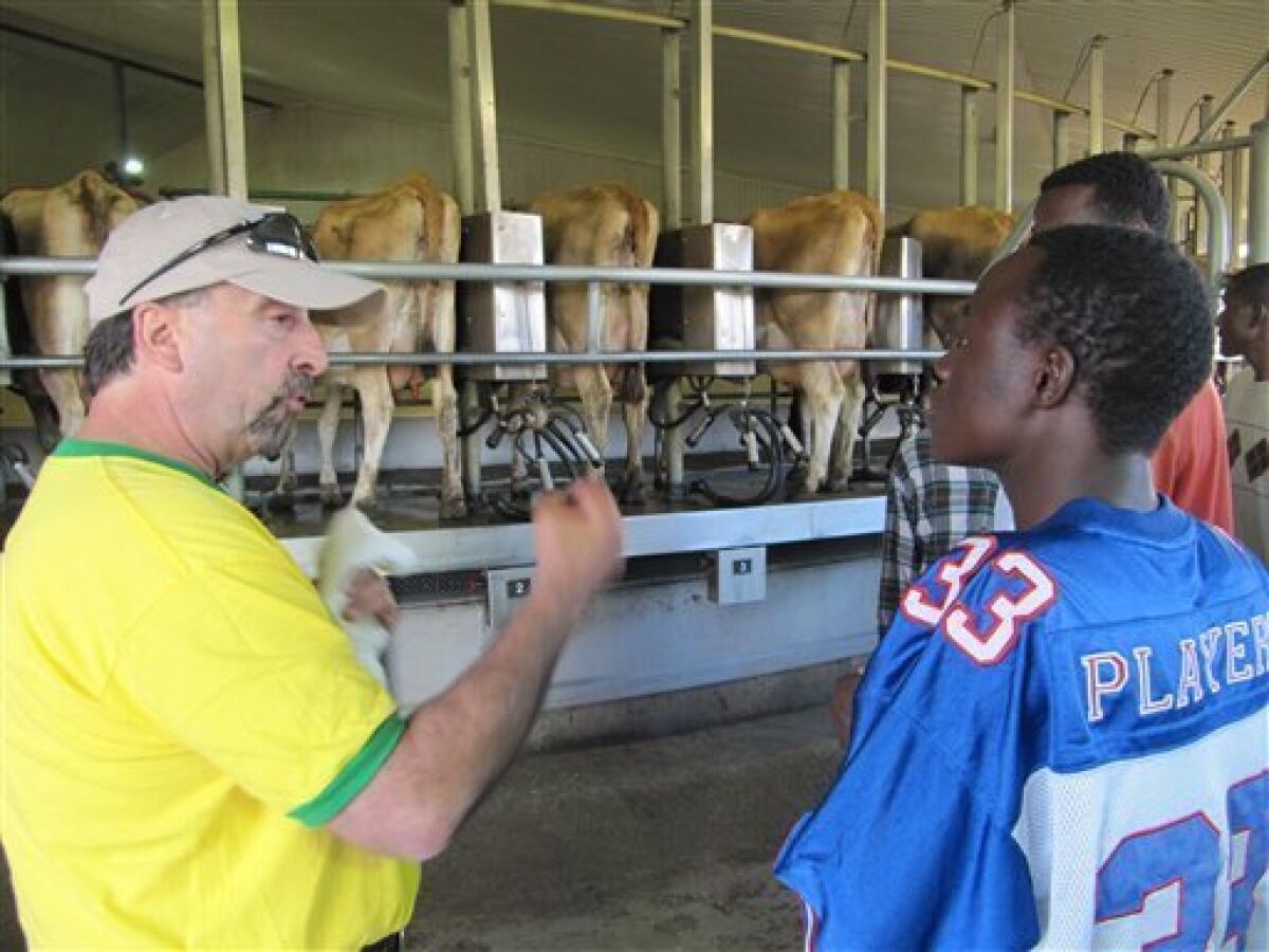In this photo taken July 23, 2010, Frank Toledo, left, explains to Abdi Abdullahi, right, how cows at Threemile Canyon Farms are milked during a tour with new workers in Boardman, Ore. There is little the International Rescue Committee, an Idaho-based refugee agency, can do to prepare its Third World clients for the vastness of the operation that is Oregon's largest dairy. But the 93,000-acre complex has provided steady jobs in a recession that makes it difficult for even highly educated refugees fluent in English to get hired. (AP Photo/Jessie L. Bonner)