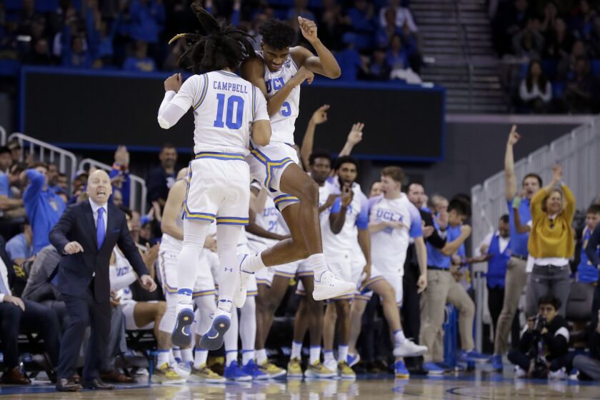 UCLA guard Chris Smith (5) celebrates with guard Tyger Campbell after scoring during the second half of the team's NCAA college basketball game against Washington in Los Angeles, Saturday, Feb. 15, 2020. (AP Photo/Chris Carlson)