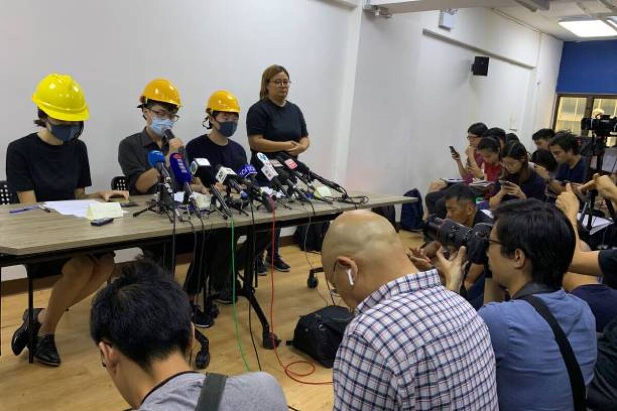 Three masked young people from Hong Kong's recent ongoing anti-government movement hold a news conference to read out a list of demands and condemn the city's pro-Beijing leaders in Hong Kong on Tuesday.