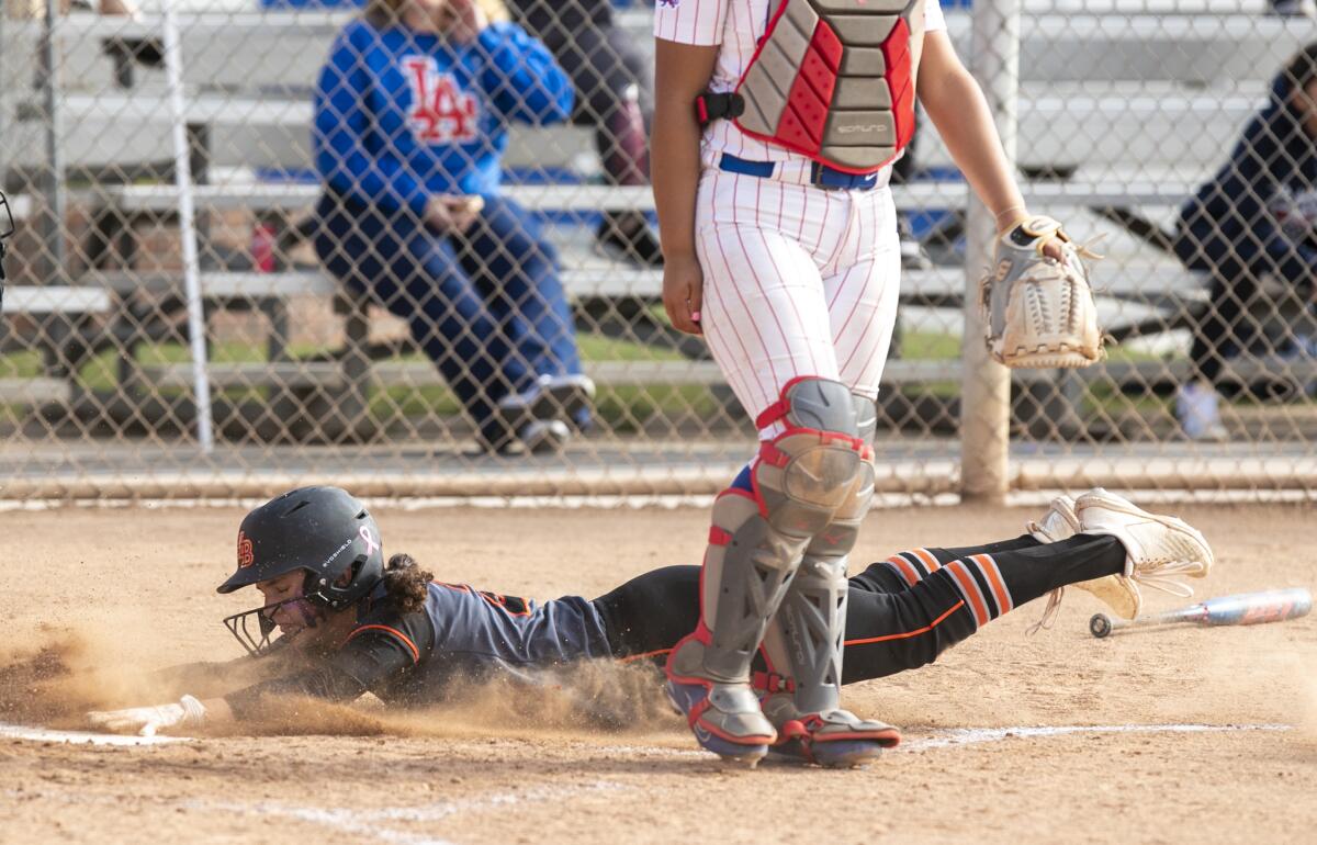 Huntington Beach's Liah Lummus scores in the sixth inning against Los Alamitos on Monday.