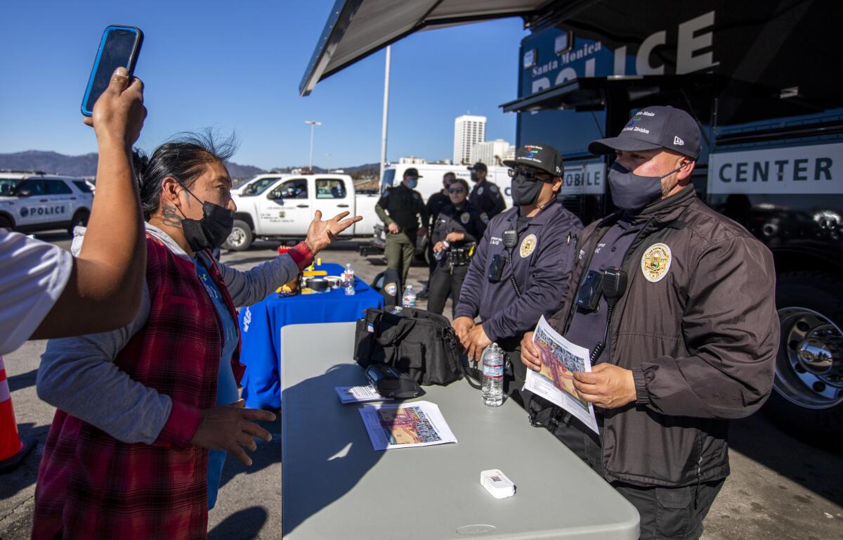 Street vendors approach city employees in the parking lot near the Santa Monica Pier on Jan. 22. 