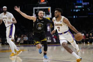 Los Angeles Lakers' Troy Brown Jr. (7) drives past Golden State Warriors' Stephen Curry.