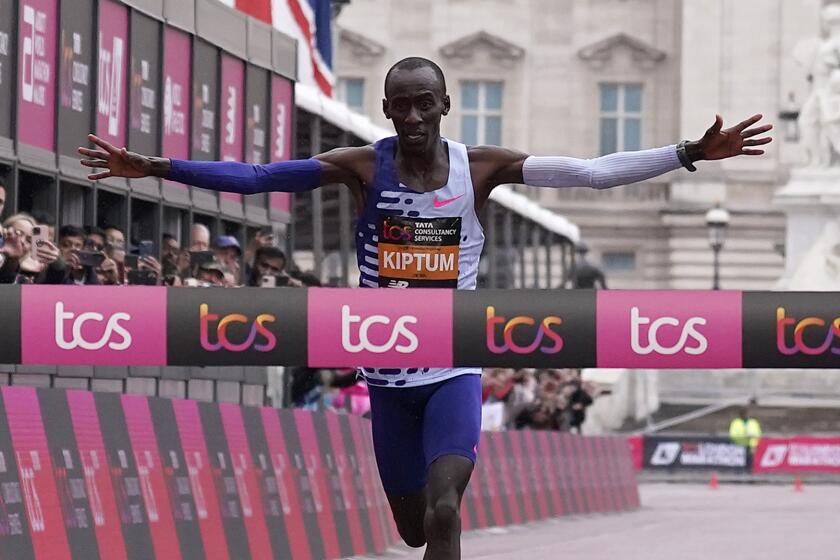 Kenya's Kelvin Kiptum crosses the finish line to win the men's race.