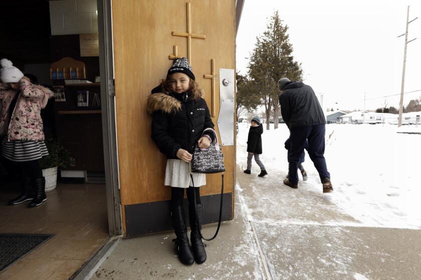 BISMARCK, NORTH DAKOTAÑDEC. 12, 2019ÑThe congregation at the Calvary Free Lutheran Church is primarily of Ukranian descent. A young girl leaves church after the survice. Burleigh County, North Dakota commissioners recently voted to continue to allow refugee resettlement in Bismarck. (Carolyn Cole/Los Angeles Times)