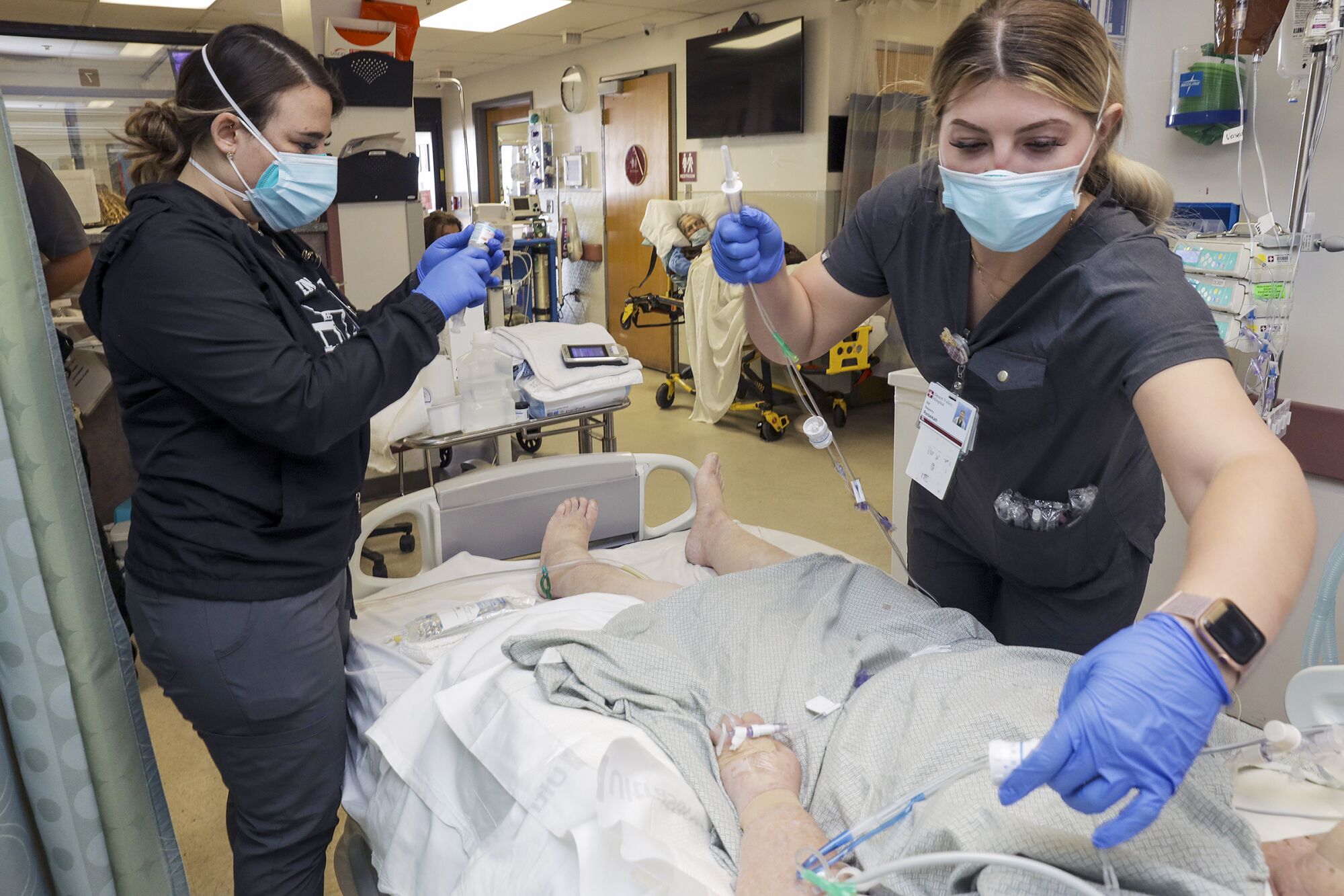 Two nurses attend to a COVID-19 patient