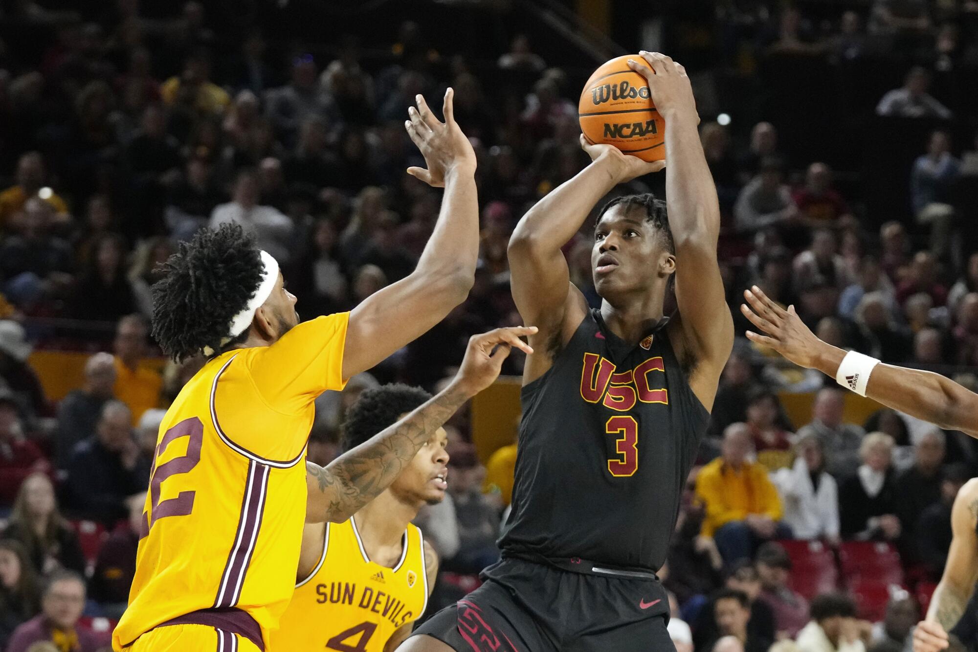 Vincent Iwuchukwu shoots over Arizona State forward Warren Washington, left, and guard Desmond Cambridge Jr.