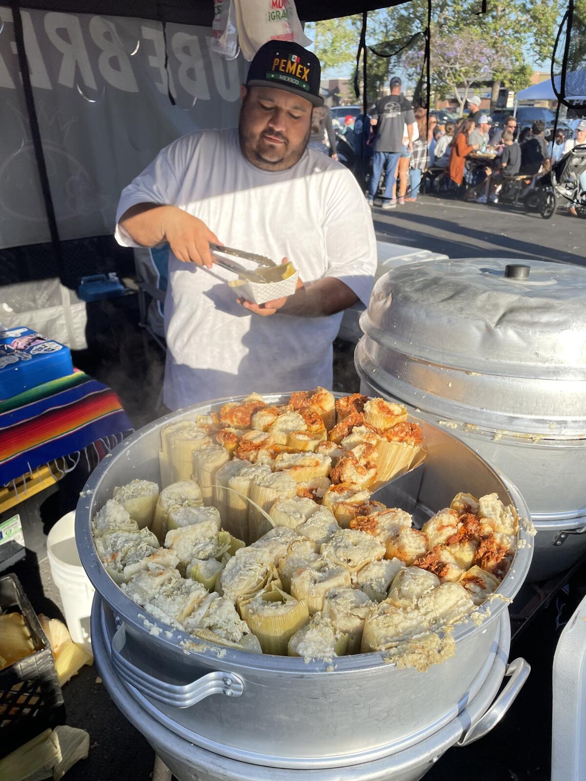 A tamale vendor readies an order at the Weekend Night Market in Huntington Beach.