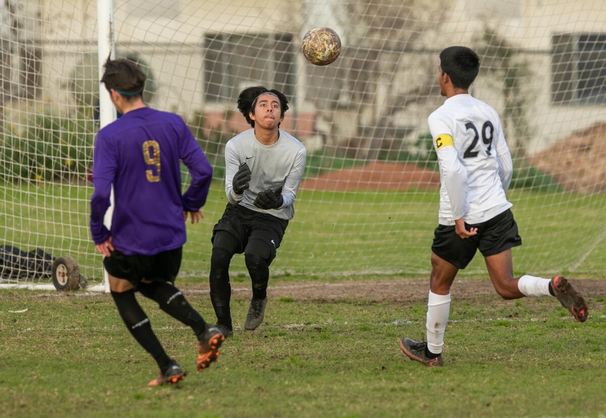 Los Amigos' goalkeeper Jorge Sanchez makes a save in a Garden Grove League boys' soccer match against Santiago on Friday.